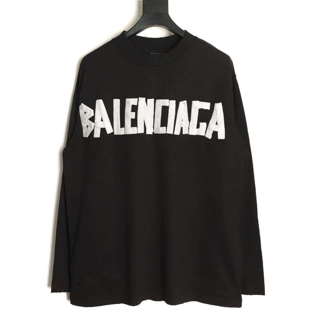 Front view of black Balenciaga long-sleeve top with bold white tape-look chest lettering